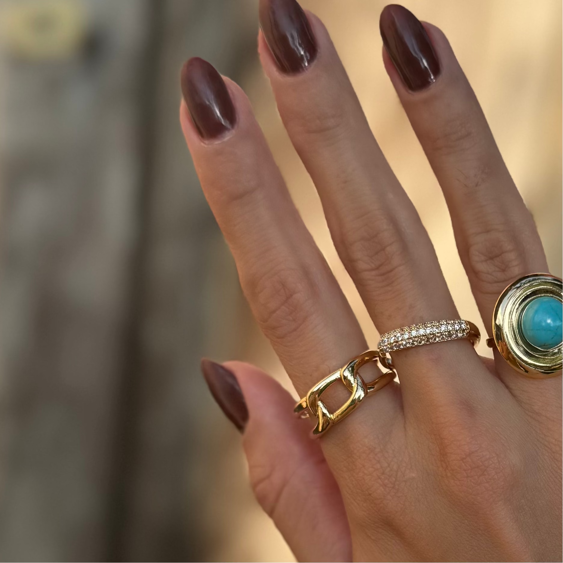 Anel dourado com design de elos em detalhe frontal